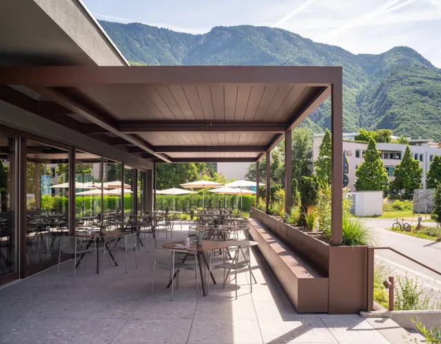 Pergola Brustor B160XL with closed louvres over a restaurant terrace
