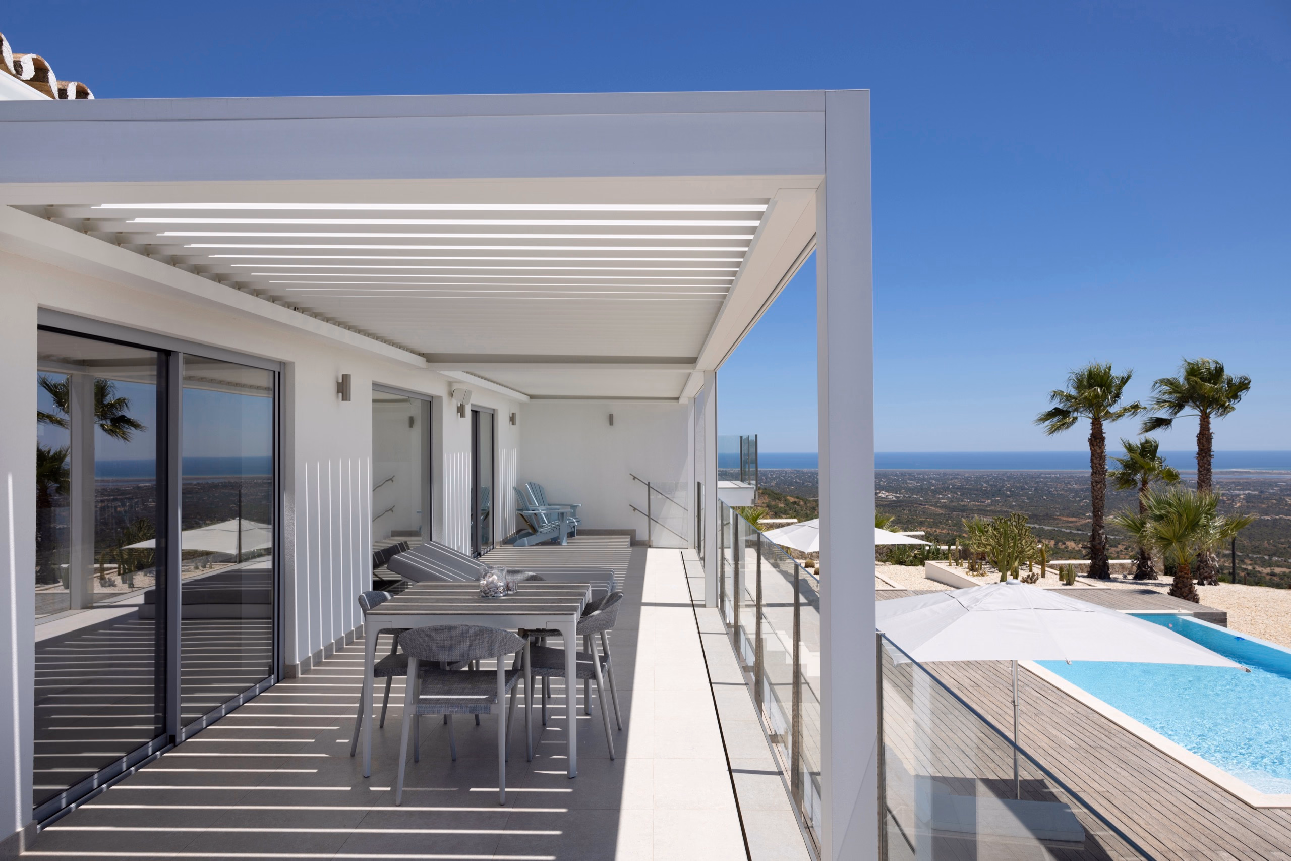 Grundstücksübersicht mit B200XL-Pergola über der Poolterrasse und Palmen