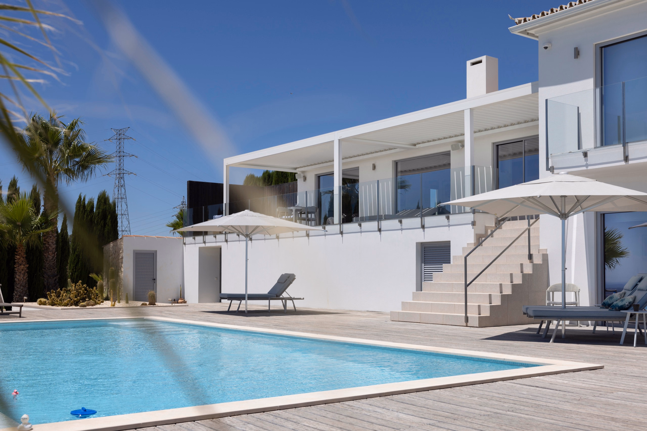Terrasse mit B200XL-Pergola, Sonnenschirm und modernem Mobiliar am Pool