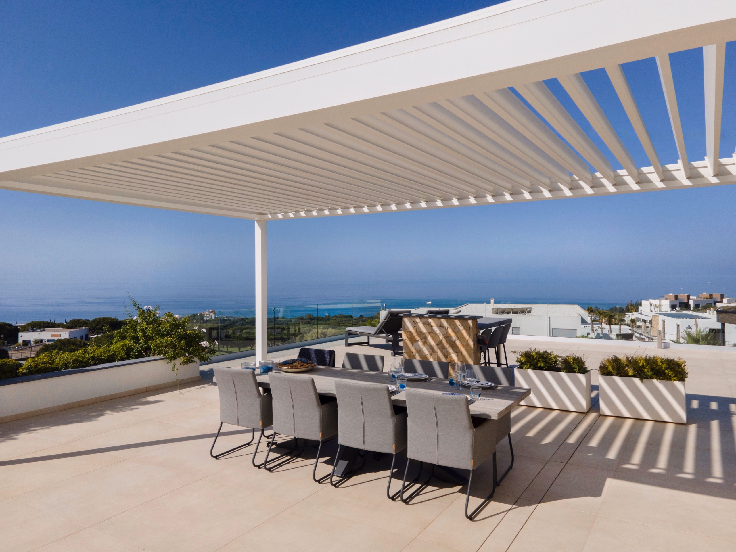 B200XL-Pergola auf einer weitläufigen Terrasse mit integrierter Beleuchtung bei Sonnenuntergang