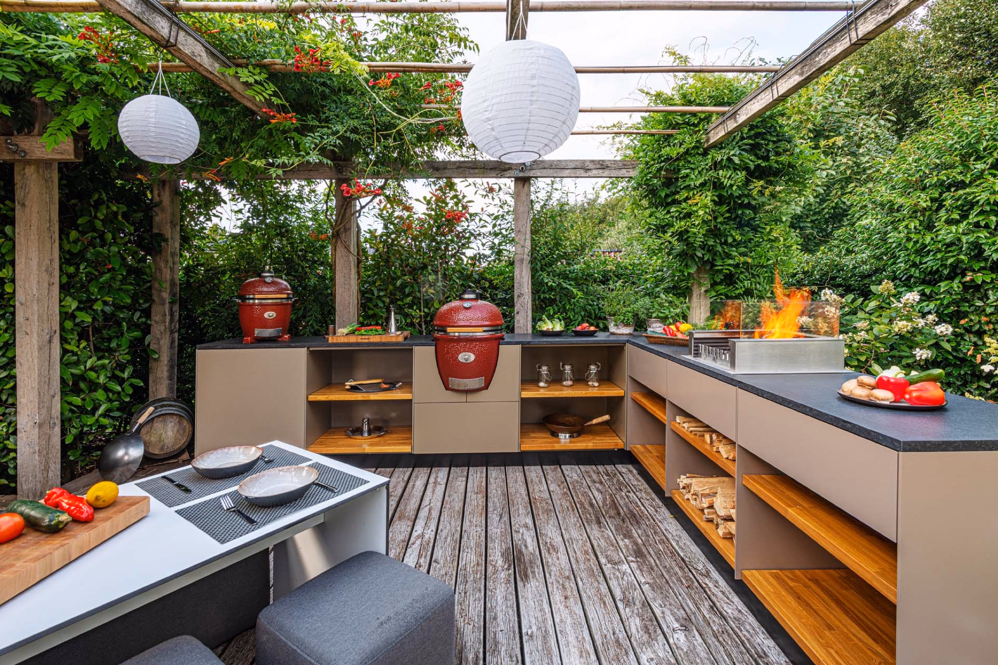 Large outdoor kitchen with two kamado grills under a glass roof